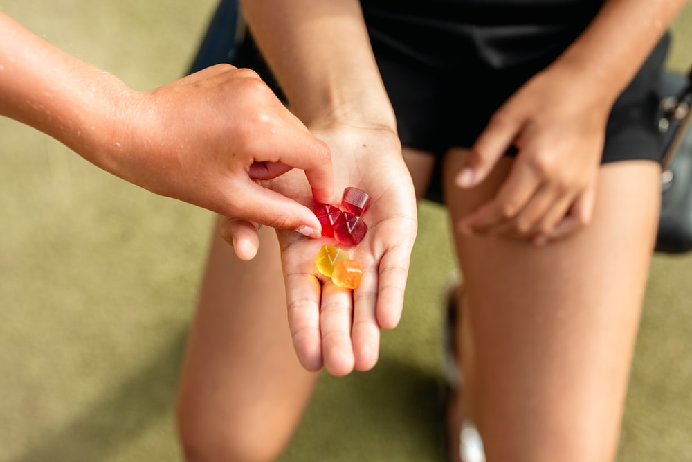 Person holding red and orange gummies