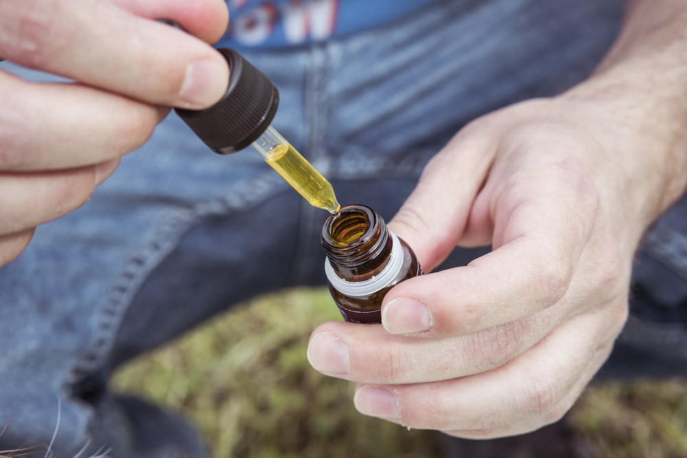 Person taking out CBD oil from a dropper